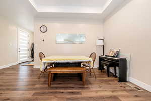 Dining space with a raised ceiling and wood finished floors