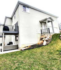 View of property exterior featuring a yard, outdoor lounge area, a patio, and stucco siding