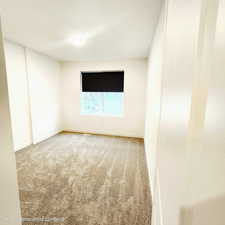 Spare room featuring light colored carpet and baseboards