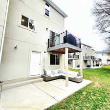 Back of property with a patio, a lawn, stucco siding, and an outdoor hangout area