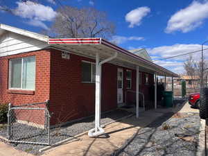 View of side of home featuring brick siding and a porch