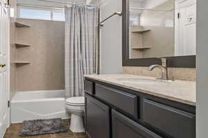 Bathroom with vanity, shower / bath combo, and healthy amount of natural light