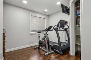 Exercise room featuring dark wood-style flooring and recessed lighting