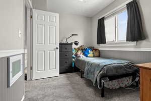 Bedroom with wainscoting and light colored carpet