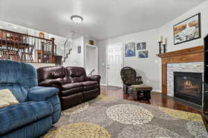 Living room featuring wood finished floors, a tiled fireplace, and a textured ceiling