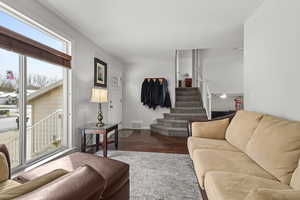 Living room with stairway and dark wood finished floors