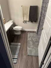 Full bathroom featuring dark wood finished floors, vanity, and a shower with curtain