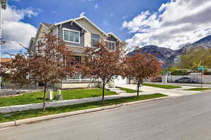 View of front of property featuring a front lawn, concrete driveway, a garage, and a mountain view