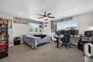 Bedroom featuring light carpet, a desk, a ceiling fan, recessed lighting, and a textured ceiling