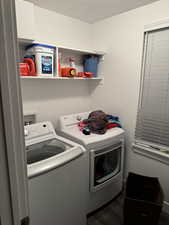 Laundry room with dark wood-style floors and separate washer and dryer
