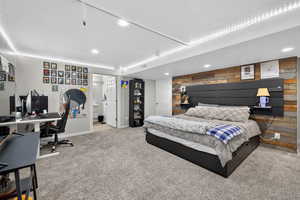Bedroom featuring an accent wall, light colored carpet, an office area, and recessed lighting