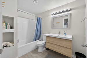 Bathroom with vanity, light wood finished floors, and shower / bath combo with shower curtain