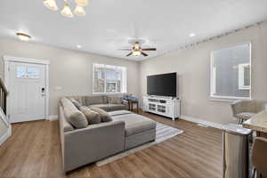 Living room featuring wood finished floors, a ceiling fan, and hanging lights