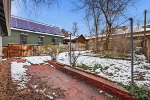 Yard covered in snow with a fenced backyard and a patio area