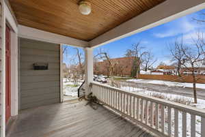 Snow covered deck featuring covered porch