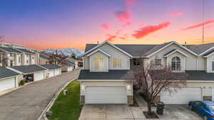 Traditional home featuring a shingled roof, driveway, a mountain view, an attached garage, and a residential view