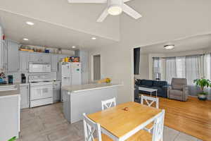 Kitchen featuring light countertops, white appliances, recessed lighting, backsplash, and gray cabinetry