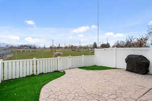Fenced backyard featuring area for grilling and a patio