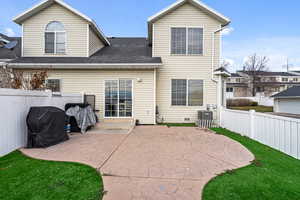 Back of house featuring a patio, a fenced backyard, and roof with shingles