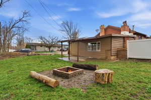 View of property exterior featuring a chimney, a fire pit, and a patio area