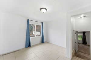 Spare room featuring baseboards and light tile patterned flooring
