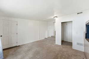 Unfurnished bedroom with a closet, light colored carpet, and a textured ceiling