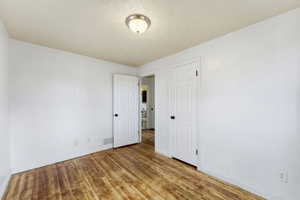 Unfurnished bedroom with light wood-style flooring and a textured ceiling
