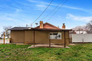 Rear view of house featuring a chimney, a mountain view, and a patio area