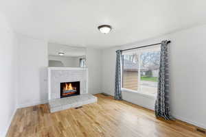 Unfurnished living room featuring a fireplace and light wood-style flooring