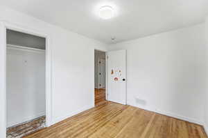 Unfurnished bedroom with light wood-style floors, a closet, and a textured ceiling