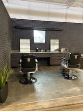 Miscellaneous room with brick wall and concrete floors