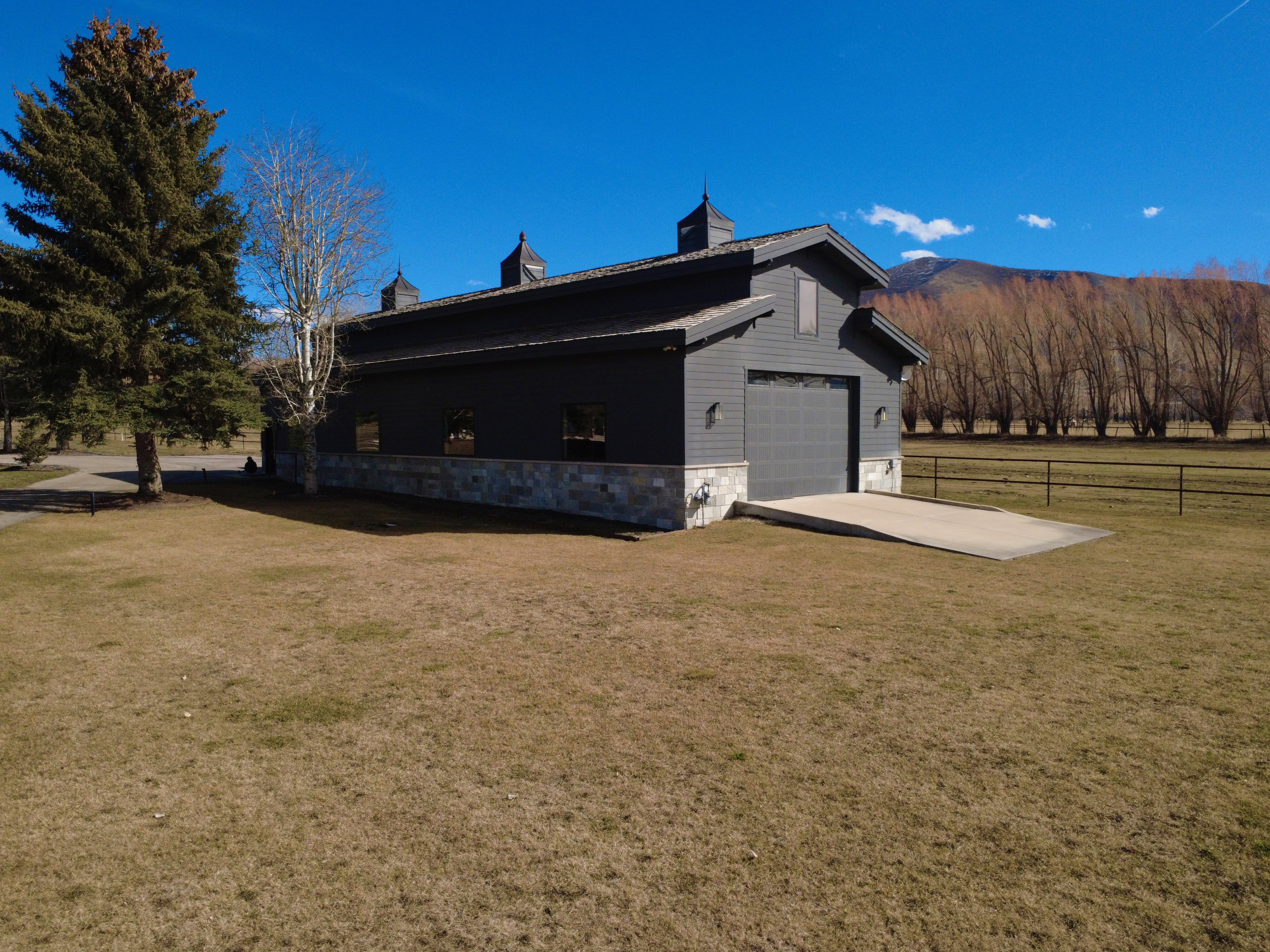 View of property exterior featuring stone siding, driveway, and a mountain view