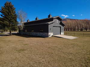 View of property exterior featuring stone siding, driveway, and a mountain view