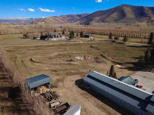 Aerial view of sparsely populated area featuring rows of crops and a mountain backdrop