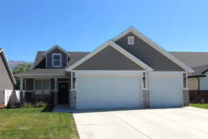 Craftsman-style house featuring stone siding, an attached 2-car garage, a concrete driveway, and a covered porch