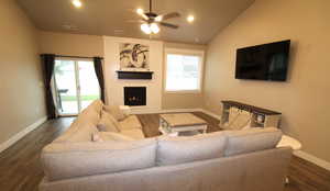 Great room with dark wood-style flooring, lofted ceiling, ceiling fan, recessed lighting, and gas fireplace.