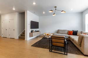 Living area featuring light wood-type flooring, a textured ceiling, and recessed lighting