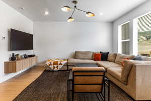 Living area with light wood-type flooring and a textured ceiling