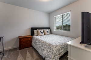 Bedroom with dark colored carpet and baseboards