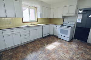 Kitchen with white cabinetry, white appliances, tasteful backsplash, light countertops, and a ceiling fan