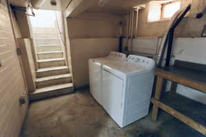 Laundry area featuring unfinished concrete flooring and washing machine and dryer