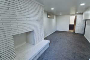 Unfurnished living room featuring dark colored carpet and recessed lighting