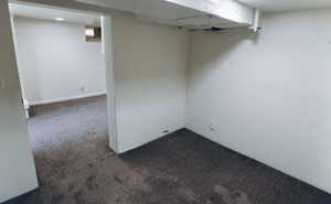 Finished basement with dark colored carpet