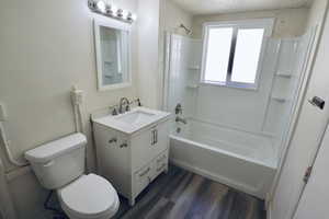 Full bath with vanity, dark wood finished floors, and tub / shower combination