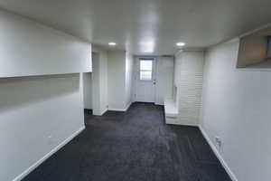 Basement with dark colored carpet and recessed lighting