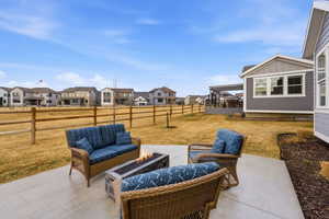 Fenced backyard with an outdoor living space with a fire pit, a patio area, and a residential view