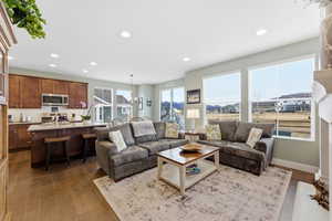 Living room with dark wood finished floors and suspended lighting