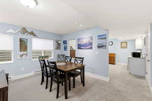 Dining area featuring light colored carpet and a baseboard heating unit