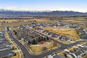 Aerial view of property and surrounding area with nearby suburban area and a mountainous background