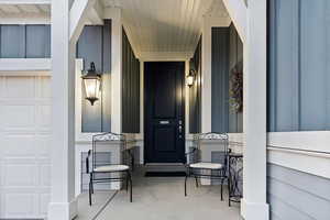 Property entrance with a porch and a garage